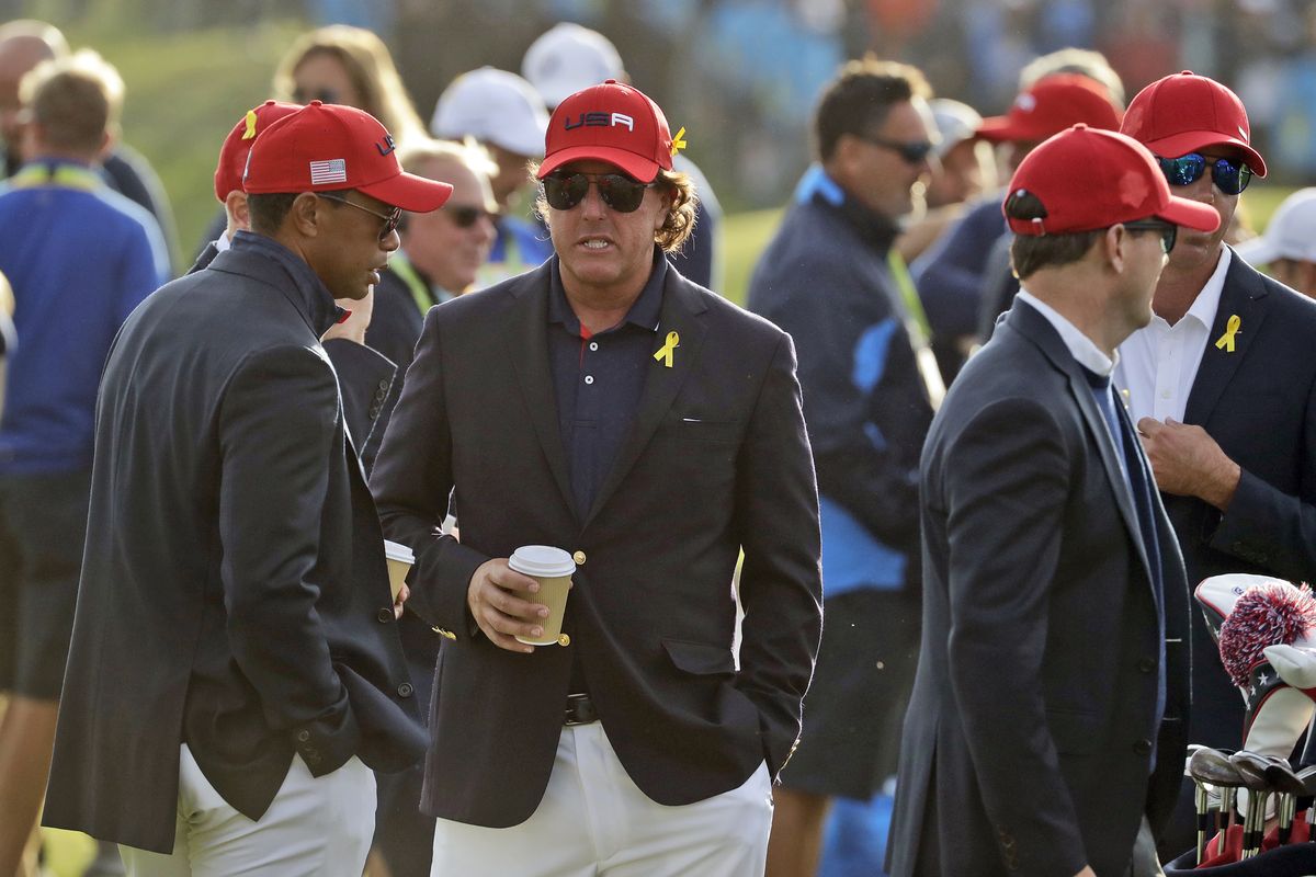 FILE - In this Sept. 30, 2018, file photo, Tiger Woods, left, and Phil Mickelson wait for the closing ceremony after Europe won the Ryder Cup on the final day of the 42nd Ryder Cup at Le Golf National in Saint-Quentin-en-Yvelines, outside Paris, France. Woods will be missng from the upcoming Ryder Cup, while Mickelson will serve as a vice-captain on the team. The pandemic-delayed 2020 Ryder Cup returns the United States next week at Whistling Straits along the Wisconsin shores of Lake Michigan.  (Matt Dunham)