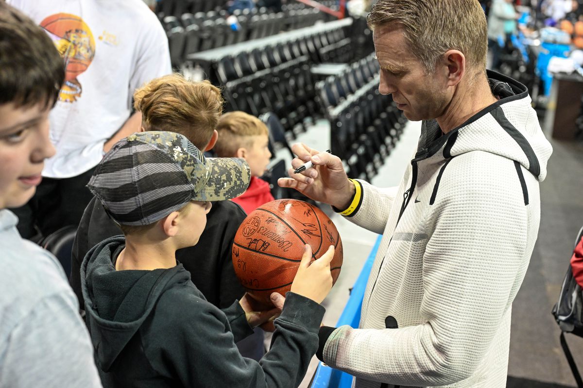 After open practice, Alabama head basketball coach Nate Oats signs a basketball for Walker Spooner, 9, Thursday, March 21, 2024, in the Spokane Veterans Arena.  (COLIN MULVANY/THE SPOKESMAN-REVIEW)