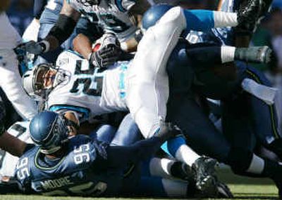 
Panthers running back Joey Harris (25) is flipped by Seahawks defensive end Rashard Moore (95) and other defenders during the first half of Seattle's win Sunday.
 (Associated Press / The Spokesman-Review)