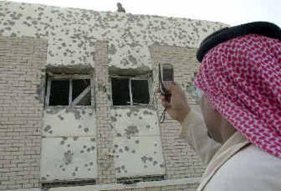 
A Kuwaiti man takes pictures of a bullet-ridden house south of Kuwait City in which a reputed terrorist leader was seized by police on Monday. 
 (Associated Press / The Spokesman-Review)