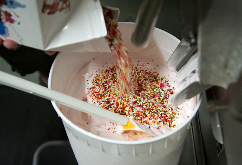 Tyler Reeves mixes colored sprinkles and frosted animal cookies into ice cream to make Brain Freeze’s Circus ice cream.