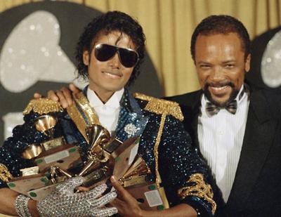 FILE - In this Feb. 28, 1984, file photo, Michael Jackson, left, holds eight awards as he poses with Quincy Jones at the Grammy Awards in Los Angeles. Jackson's estate announced Aug. 7, 2017, that a 3-D version of his iconic 