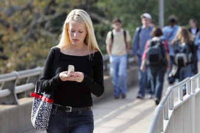 
Christina Rainie, 19, left, checks her cell phone as she and other students make their way between classes at the University of Georgia.
 (Associated Press photos / The Spokesman-Review)
