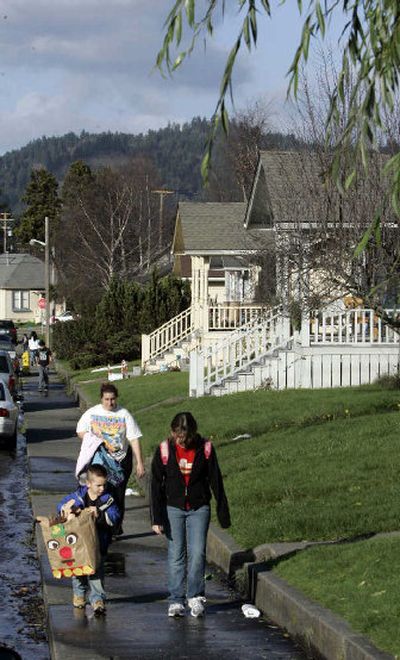 
John Ball, 5, left, and his sister Yvonne, 11, right, walk home from school, followed by their mother, Jonna Ball, in Scotia. 
 (The Spokesman-Review)