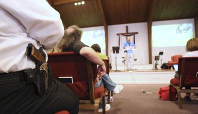 Cliff Meadows wears his firearm as he listens to pastor Ken Pagano during a service at  New Bethel Church  in Louisville, Ky., on Saturday.  (Associated Press / The Spokesman-Review)