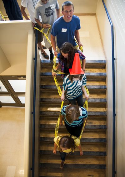 Taped togetherness: Strung together by caution tape, Gonzaga Preparatory School freshmen take a grand tour of the school Monday morning. Seniors led groups of new students, who dressed in costumes, during freshman orientation. Classes start Thursday at Gonzaga Prep. (Colin Mulvany)