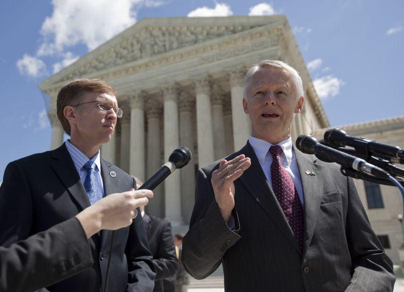 Washington Attorney General Rob McKenna, left, looks on as Washington Secretary of State Sam Reed talks with media outside the Supreme Court in Washington, Wednesday, April 28, 2010, after a court case on whether the names on a petition asking for the repeal of Washington state's domestic partnership rights should be kept secret. (Evan Vucci / Associated Press)