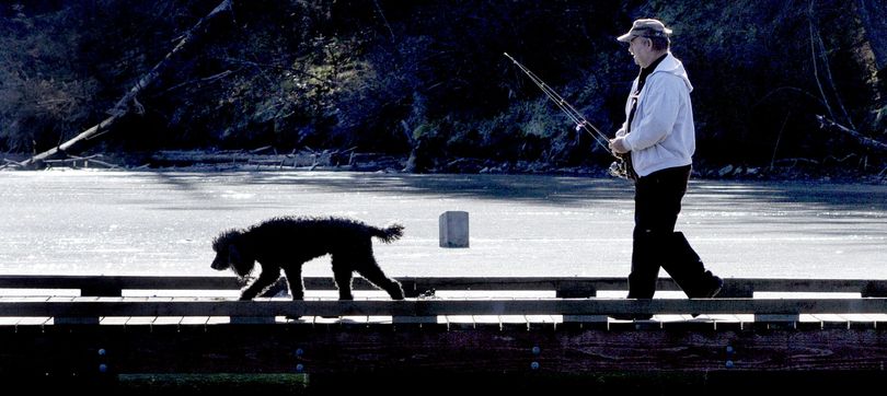 Fighting a fever. “Cabin fever got the best of me,” Fred Estes, of Post Falls, said after trying out his new swamp-skipping mucklucker fishing lure on a partially frozen Fernan Lake with his dog Hannah in Coeur d’Alene on Monday. (Kathy Plonka)