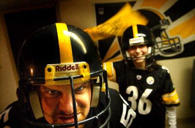 
Pittsburgh Steelers' fans Mo Owen and his wife, Julie, turned the basement of their North Side home into a shrine of Steeler memorabilia decked out in black and gold.  Below: A photo captures Owen and his late dog, 