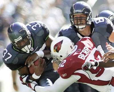 
Seahawks running back Shaun Alexander fights for yardage as he is tackled by Arizona's Bertrand Berry in the first quarter. Alexander ran for 140 yards and scored four rushing touchdowns. 
 (Associated Press / The Spokesman-Review)