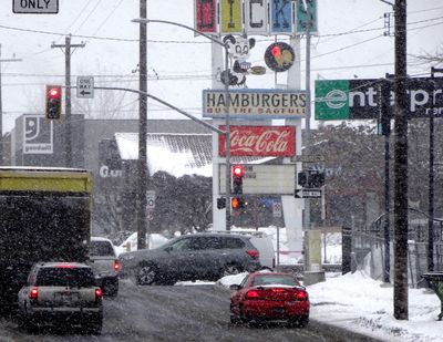 Traffic on Third Avenue in downtown Spokane moves through a curtain of snow Wednesday, February 8, 2017. (Jesse Tinsley / The Spokesman-Review)