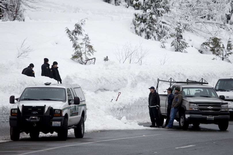 King County Sheriff's officers and other emergency officials work along Highway 2 near Stevens Pass ski resort in Skykomish, Wash., near where three skiers were killed in an avalanche Sunday, Feb. 19, 2012. The avalanche swept the three skiers about a quarter-mile down an out-of-bounds canyon at the popular resort. A fourth skier caught up in the slide was saved by a safety device, authorities said.  (Associated Press)