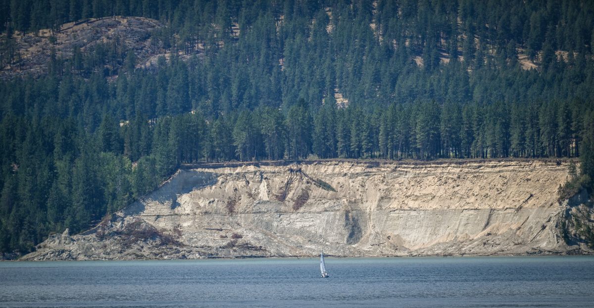 A sailboat drifts past the site of a massive landslide across from the beach at Colville Flats on Lake Roosevelt Wednesday. Seismic records show that it likely happened in November. It generated large waves of 11 to 14 feet high that went across and inundated Colville Flats beach. No one was injured.  (Jesse Tinsley/The Spokesman-Review)