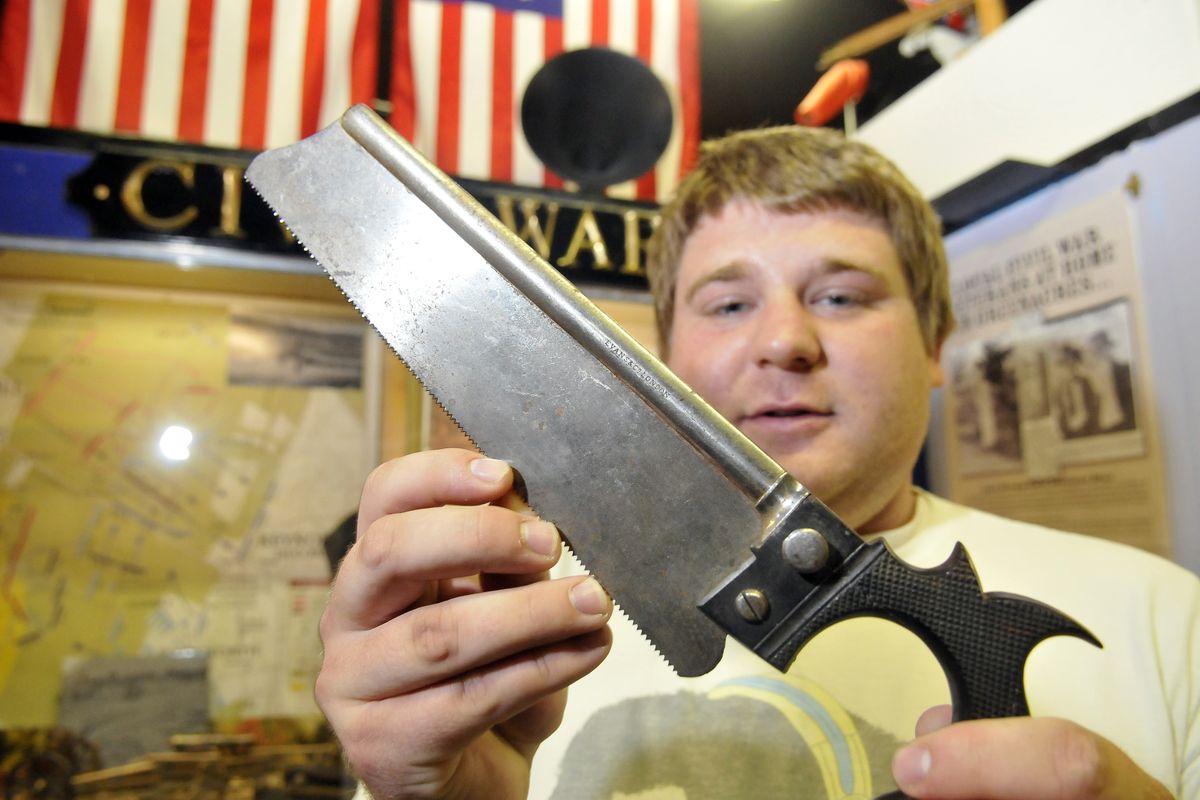 Tyler Robbins, an Eastern Washington University history major who volunteers at the Spokane Valley Heritage Museum, holds a Civil War-era surgeon’s bone saw Tuesday at the museum. (Jesse Tinsley)