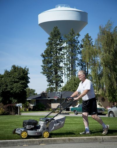 Rupert Butler, who is retired and moved to the Inland Northwest last year from Texas, has a lush, green lawn. Butler lives in the Modern Water District. One of Modern’s water towers looms nearby. (Colin Mulvany)