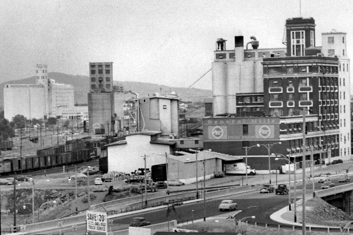 1954 - This photo shows three large grains storage and processing plants in East Spokane. In the foreground at right is the Sperry flour mill. In the center is the Spokane terminal of North Pacific Grain Growers, Inc., and to the far left is the huge Centennial Flouring Mills company plant. Each is strategically located along tracks in the rail corridor through East Spokane. (THE SPOKESMAN-REVIEW PHOTO ARCHIVE / SR)