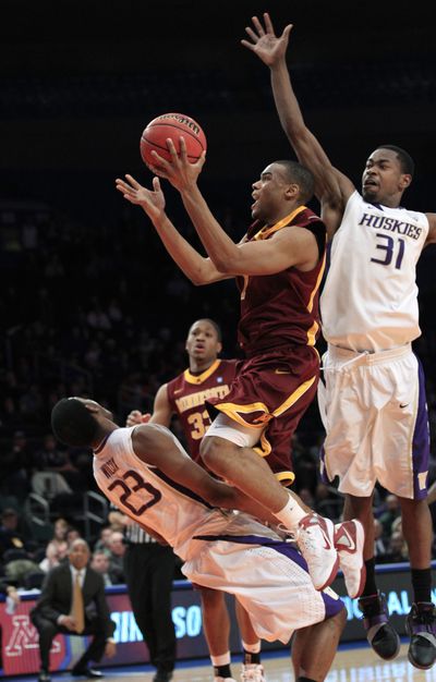 Minnesota’s Andre Hollins drives past UW’s Terrence Ross and into C.J. Wilcox during overtime. (Associated Press)