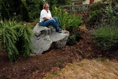 
Surrounded by drought-resistant plants, Rachael Paschal Osborn sits on a rock in her yard outside her home  in Spokane. Paschal Osborn, co-founder of the Columbia Institute for Water Policy, has chosen to maintain a yard and garden that conserves water. Associated Press
 (Associated Press / The Spokesman-Review)