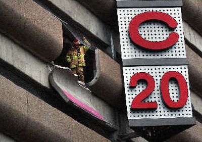 
A firefighter peers out of the River Park Square parking garage on April 8 after  Jo Savage drove through the barricade and onto a ramp below. 
 (Liz Kishimoto / The Spokesman-Review)