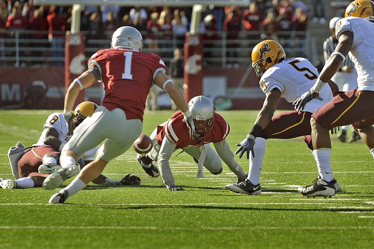 WSU’s Daniel Blackledge, center, watches his first-half fumble bounce away as ASU moves in to recover the ball.  (CHRISTOPHER ANDERSON / The Spokesman-Review)