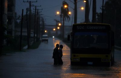 Two men wade  toward a bus during the passing of Hurricane Paloma in Camaguey, Cuba, Saturday,  (Associated Press / The Spokesman-Review)