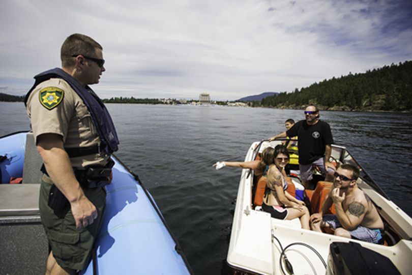 Josh Sterns, a Kootenai County Sheriff Recreation Safety deputy with  answers a boater's question about beaching near Tubbs Hill Thursday while patrolling Lake Coeur d'Alene. (Shawn Gust/press)