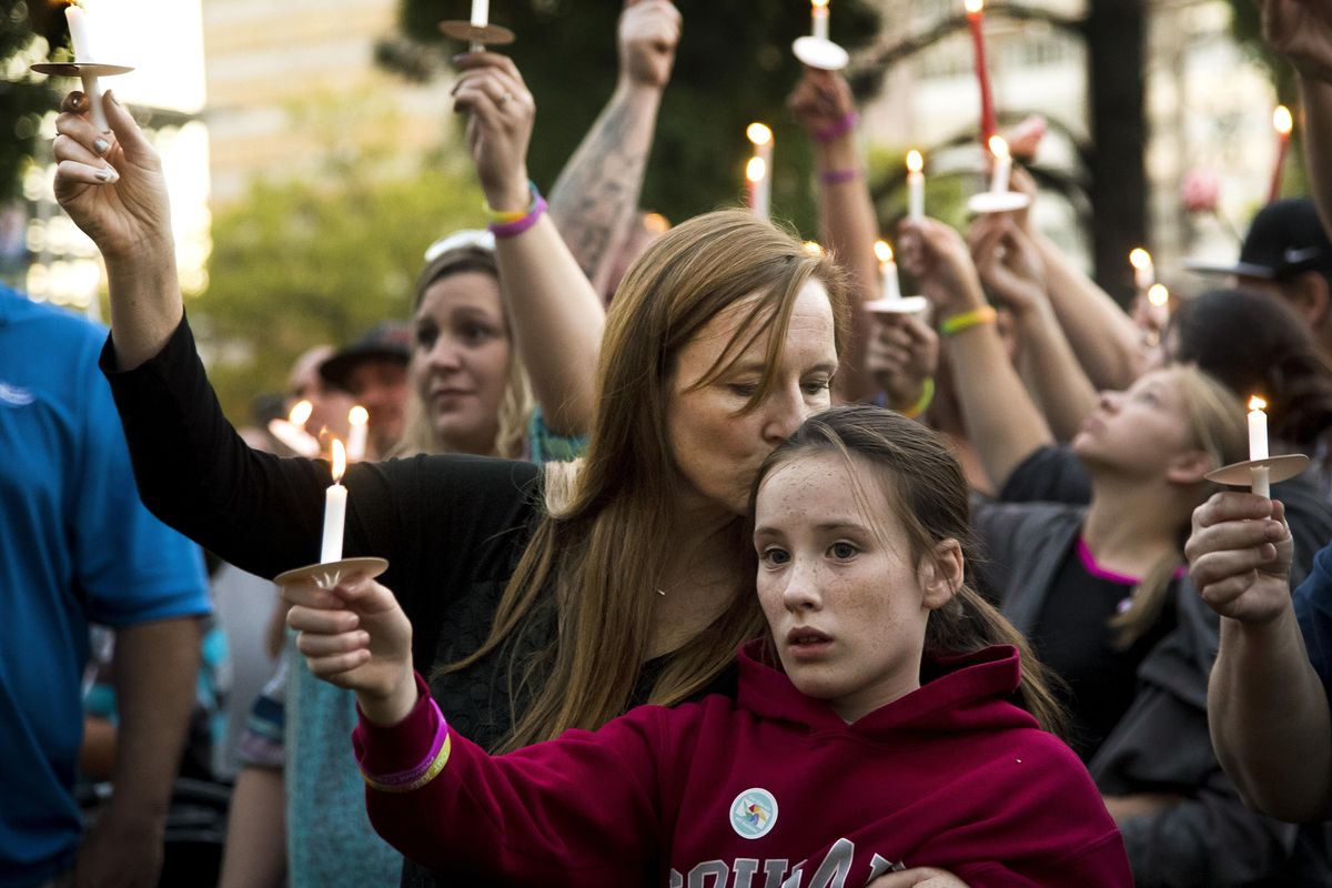 During a candlelight vigil in Riverfront Park, Deanne Wilson and her daughter Katelyn,10, raise their candles in memory of the three babies/toddlers killed by homicide or neglect and a fourth left with serious injuries in the past couple months. The event, attended by over 200 people was sponsored by Our Kids Our Business on Sept. 28, 2016. (Colin Mulvany / The Spokesman-Review)