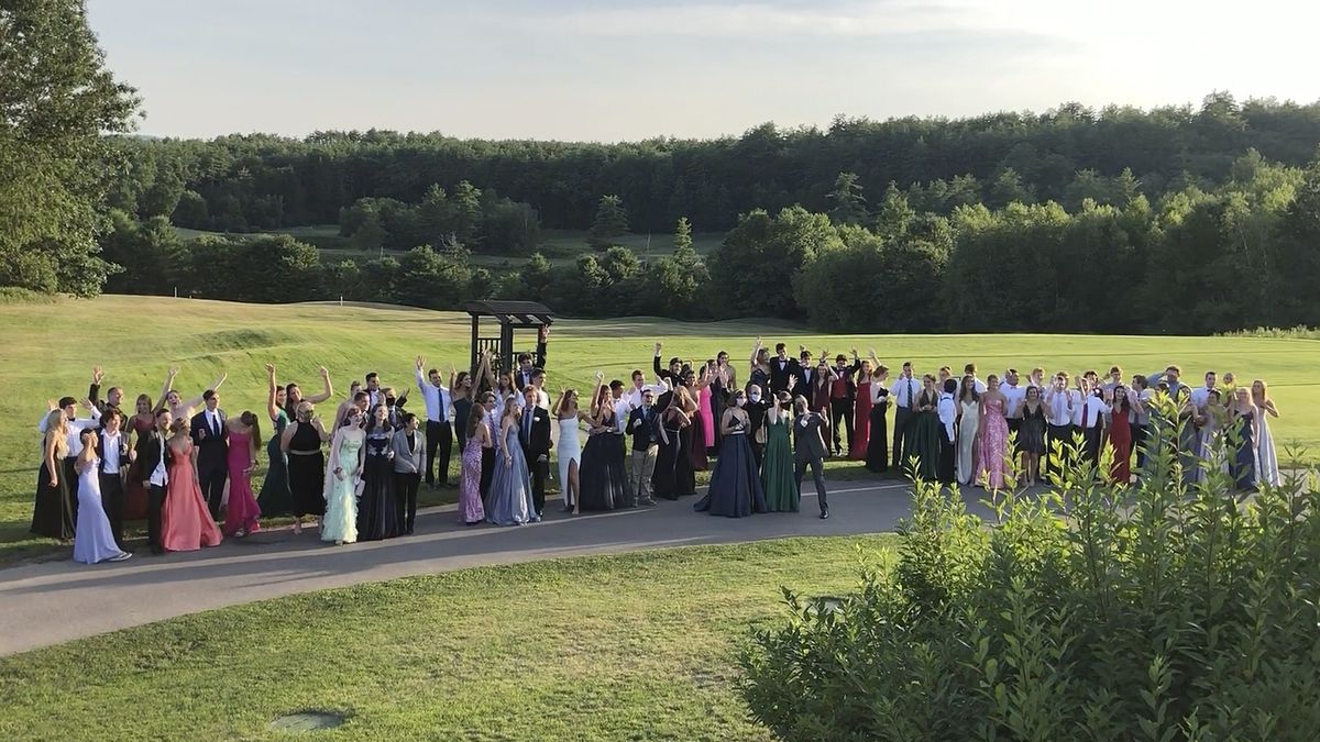 In this Saturday, July 18, 2020, image provided by Carol Justic, recent Bedford High School graduates and students pose for a photo at their outdoor prom outdoor at the Stonebridge Country Club in Goffstown, N.H., organized during the coronavirus pandemic. Amid the debate over how to reopen schools safely, some teens and parents are organizing private proms to replace events canceled because of the coronavirus.  (Carol Justic)
