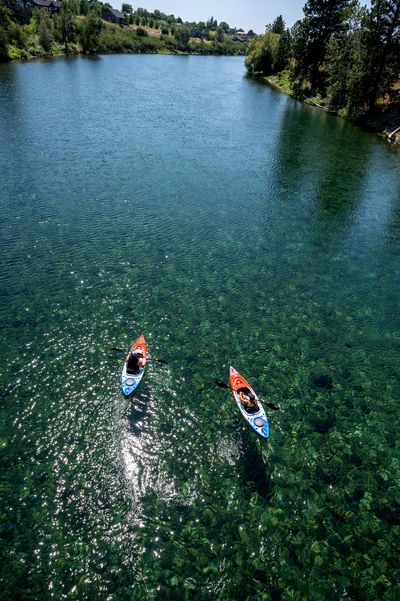 Tim Holman and his son, Trevor, 9, beat the heat Friday as they kayak the Spokane River below Plante’s Ferry Stadium in Spokane Valley.  (COLIN MULVANY/THE SPOKESMAN-REVIEW)