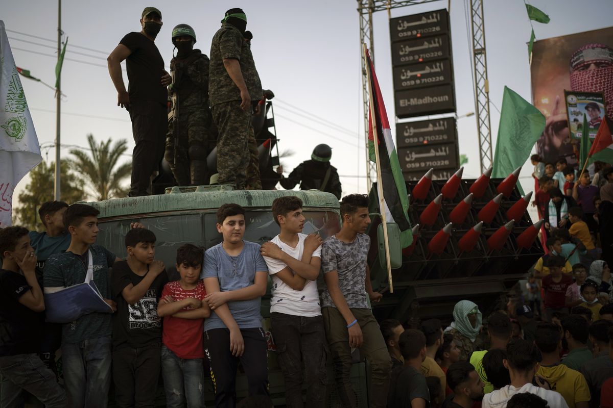 Palestinians gather as Hamas militants parade at a rally just over a week after a cease-fire was reached in an 11-day war between Hamas and Israel on Sunday in Beit Lahia, northern Gaza Strip.  (Felipe Dana)