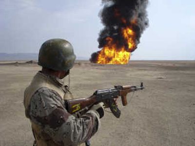 
An Iraqi soldier stands guard as a pipeline burns after an explosion northeast of Tikrit on Monday. Associated Press
 (Associated Press / The Spokesman-Review)