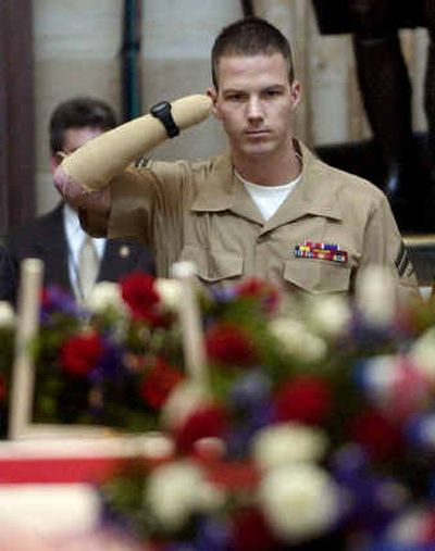 
Cpl. James E. Wright, who lost both hands in the war in Iraq, salutes the former president's casket on Thursday. 
 (Associated Press / The Spokesman-Review)