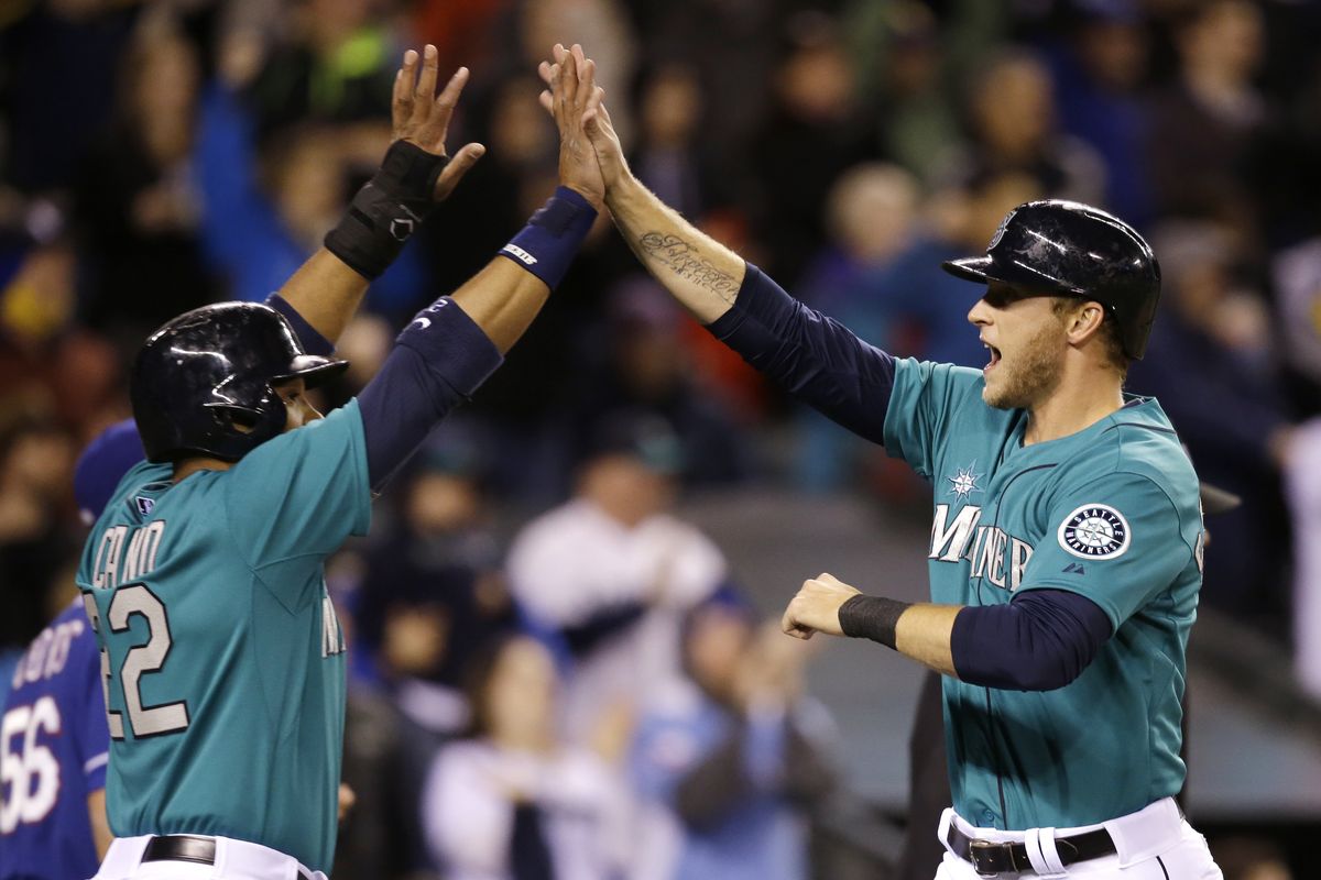 Robinson Cano and Michael Saunders, right, celebrate as they score in the 8th. (Associated Press)
