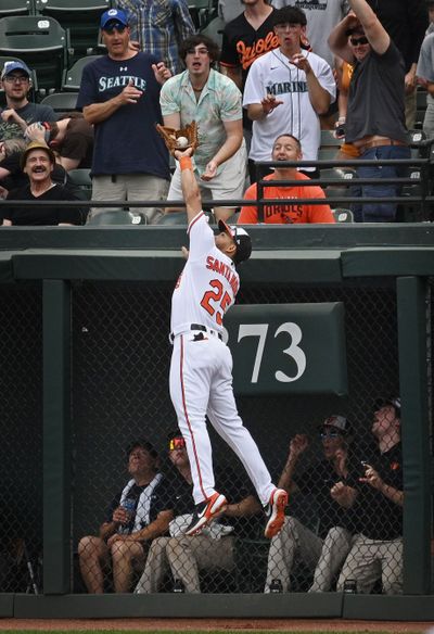 Orioles right-fielder Anthony Santander leaps above the fence in right-center to rob the Seattle Mariners' Julio Rodríguez of a home run in the first inning.  (Tribune News Service)