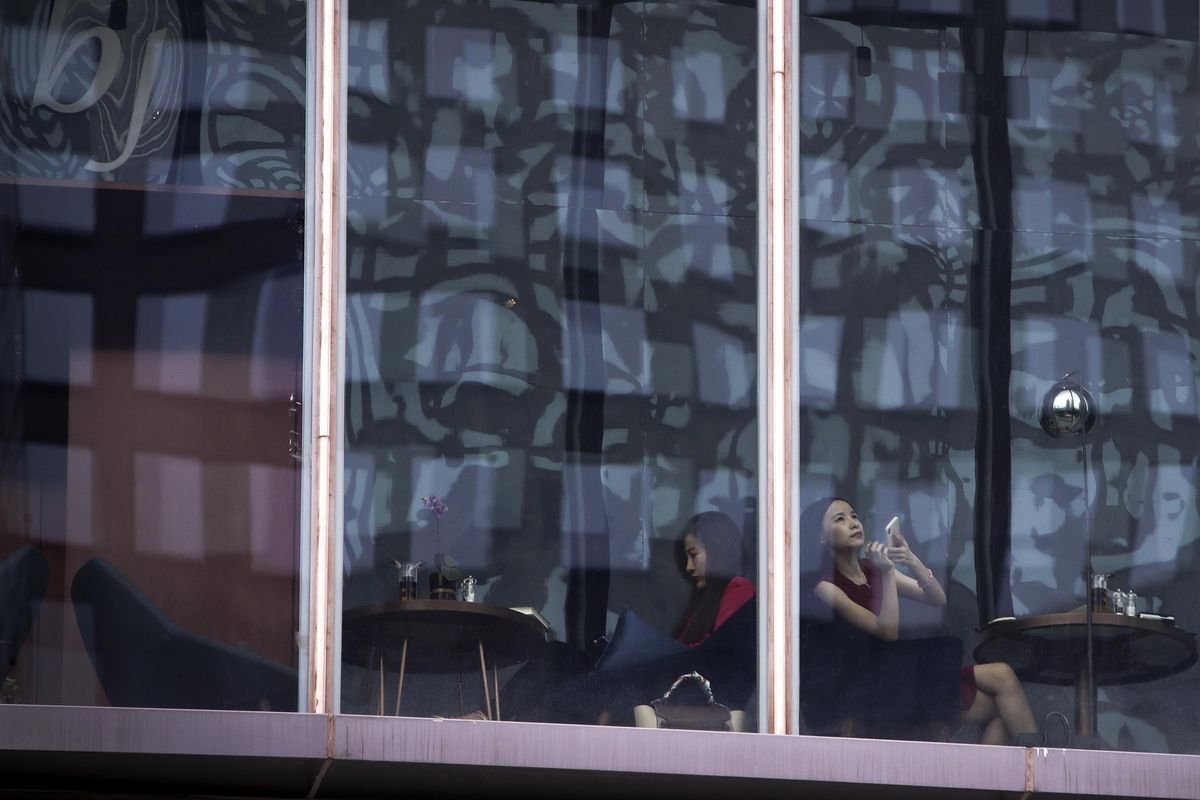 Women spend time in a cafe at the capital city’s popular shopping mall in Beijing, Monday, July 16, 2018. China’s economic growth slowed in the quarter ending in June, adding to challenges for Beijing amid a mounting tariff battle with Washington. (Andy Wong / Associated Press)
