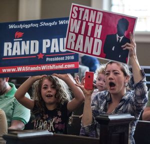 Ariel Stieben, left, and her mother, Kelly Pense hold signs in support of Republican presidential candidate Sen. Rand Paul, R-Ky during a rally in Seattle's Town Hall on Wednesday, Aug. 26, 2015. (Steve Ringman/The Seattle Times via AP) 
