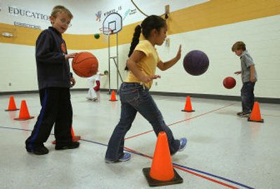 
Seven-year-old first-graders Banesa Segoviano,  center, and Tucker Walters,  left, work on hand-eye coordination during a class at Moore Elementary in Franklin, Tenn., last month. 
 (Associated Press / The Spokesman-Review)