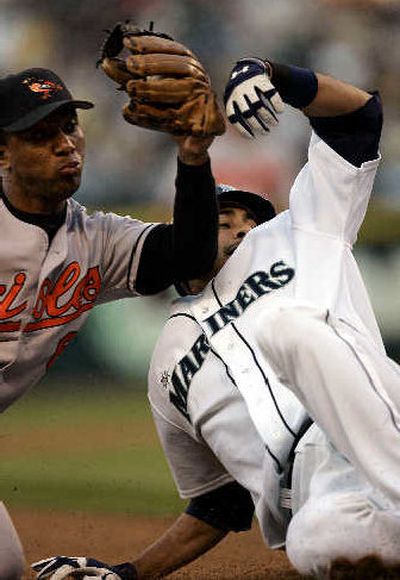 
Baltimore Orioles third baseman Melvin Mora, left, follows through with tag on Mariners' Mike Morse in the fourth inning. Morse tried to stretch a double into a triple and was out on the play. Seattle's rookie shortstop later drove in the winning run with a ninth-inning single.
 (Associated Press / The Spokesman-Review)