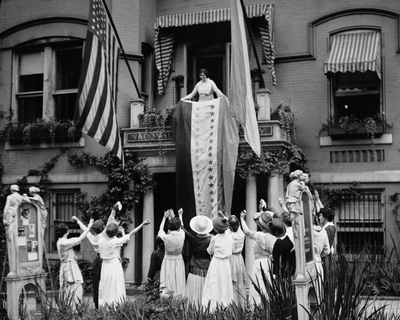 Alice Paul, chair of the National Woman’s Party, unfurls a banner after the ratification of the 19th Amendment on Aug. 19, 1920, at the NWP’s headquarters in Washington.  (The Crowley Company/Library of Congress via the Associated Press)