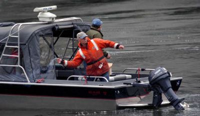 
Devices are thrown into the water during a sea lion hazing experiment near Bonneville Dam outside North Bonneville, Wash. Sea lions feasting on Chinook salmon at Bonneville Dam were chased off using underwater firecrackers and noisemaking guns that biologists hope will keep them away for good. 
 (File Associated Press / The Spokesman-Review)
