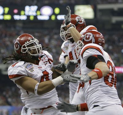 Utah’s Matt Asiata, left, Colt Sampson, center, and Chris Joppru celebrate a TD.  (Associated Press / The Spokesman-Review)