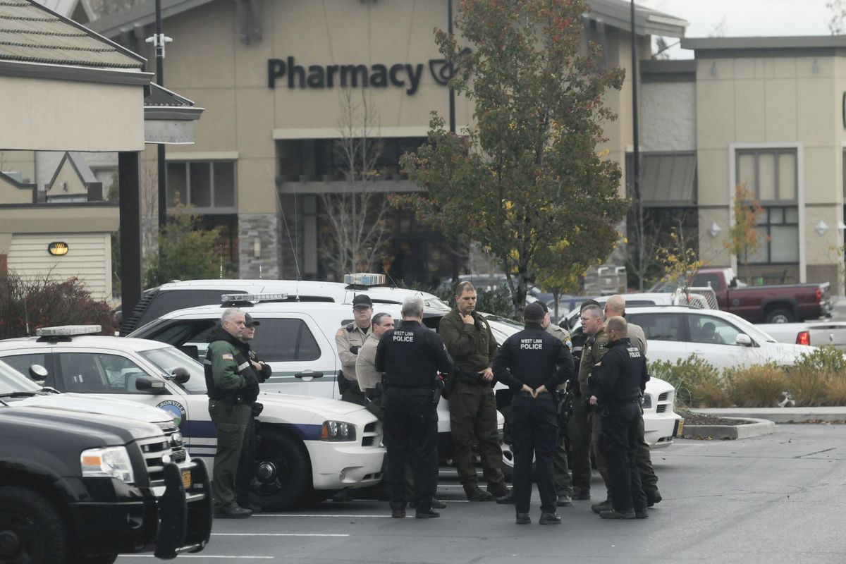 Regional officers gather near the Oregon City Police Department on Sunday after an Oregon City police officer was shot while responding to a fire. A man suspected of shooting the police officer was later found dead, authorities said Sunday. (Associated Press)
