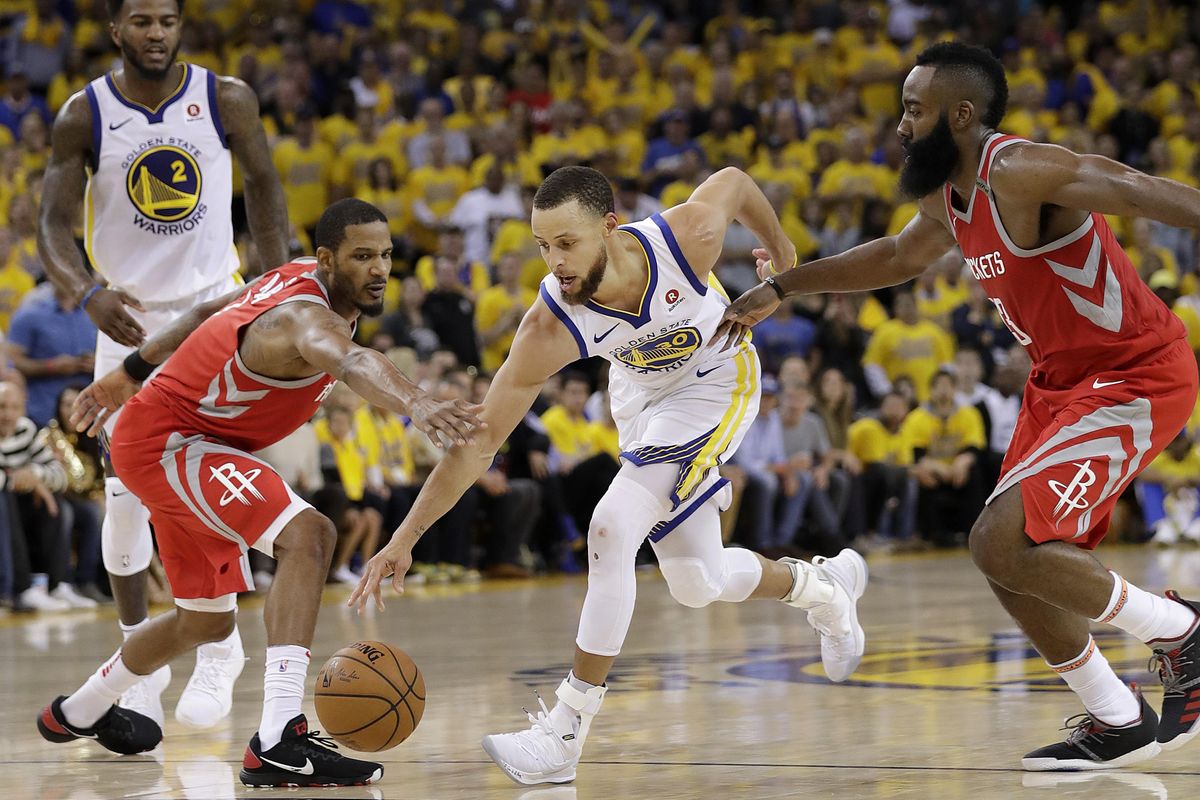Golden State Warriors guard Stephen Curry, center, dribbles between Houston Rockets forward Trevor Ariza, left, and guard James Harden during the second half of Game 6 of the NBA basketball Western Conference Finals in Oakland, Calif., Saturday, May 26, 2018. (Marcio Jose Sanchez / Associated Press)