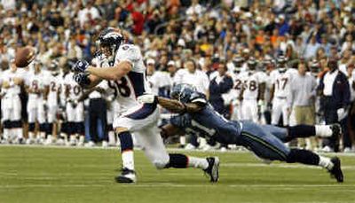 
Denver's Jeb Putzier (88) is hampered by Ken Lucas.
 (Associated Press / The Spokesman-Review)