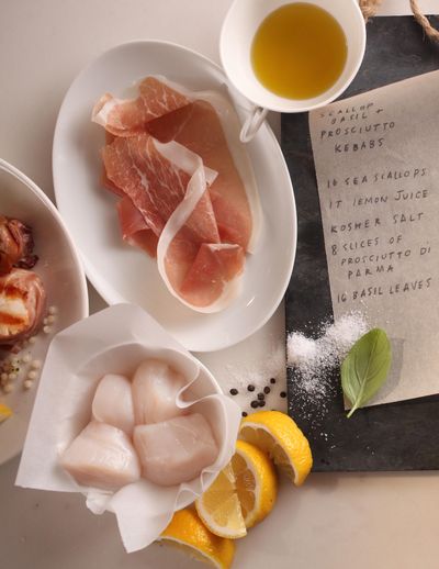 This June 2015 photo shows the ingredients for citrus marinated scallop and prosciutto kebabs in Riverside, Conn. This dish puts scallops at the center of a skewer’s worth of very tasty kebabs. It requires no more than 15 minutes hands-on time and 40 minutes total from start to finish. (James Ogle / Associated Press)