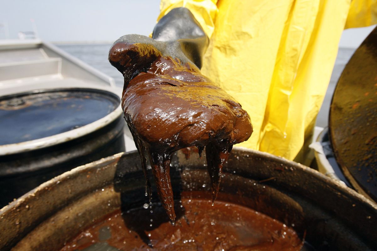 Cline holds oil he collected  in Barataria Bay.  (Associated Press)