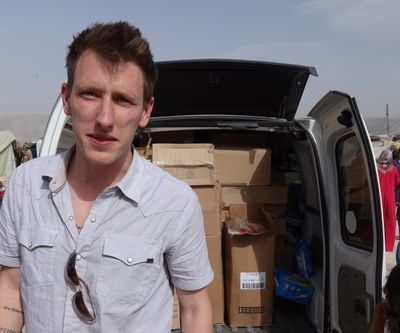 This undated photo shows Peter Kassig in front of a truck filled with supplies for Syrian refugees. (Associated Press)