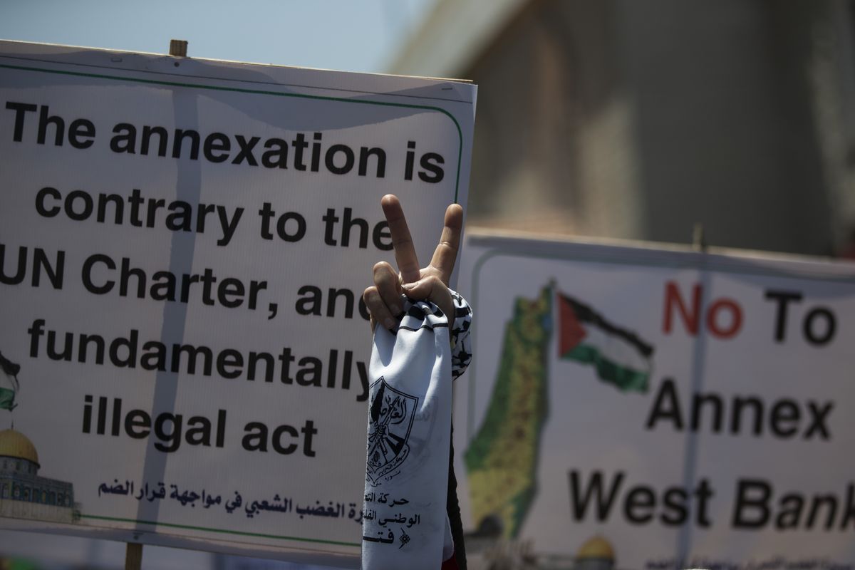 A Palestinian woman flashes the victory sign as she demonstrates against Israeli plans for the annexation of parts of the West Bank, in Gaza City, Wednesday, July 1, 2020. (Khalil Hamra)