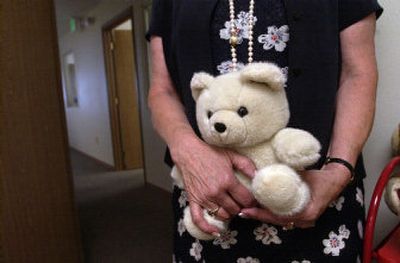 
A counselor holds a bear Monday used for comforting children at the Coeur d'Alene Women's Center, which received a $14,500 donation from proceeds raised through the Ironman Race. 
 (Brian Plonka / The Spokesman-Review)