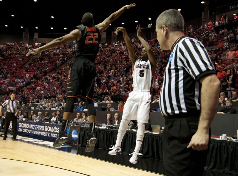 Gonzaga's Gary Bell. Jr., hit a 3-point shot over Oklahoma State's Markel Brown in the first half, March 21, 2014, at the NCAA Division I Men's Basketball Championship second round game in San Diego. (The Spokesman-Review)